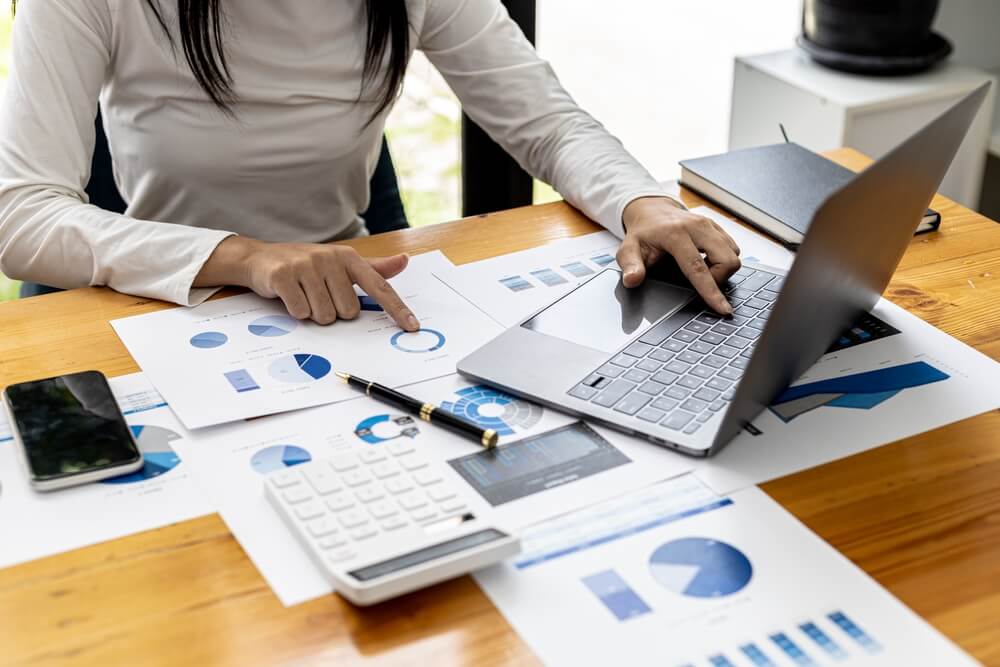 CRO_A businesswoman is checking company financial documents and using a laptop to talk to the chief financial officer through a messaging program. Concept of company financial management.