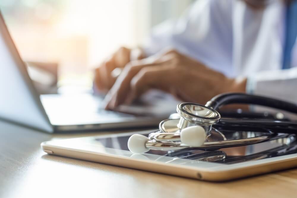 medical seo_Doctor working on laptop computer with medical stethoscope and digital tablet on the desk at office in clinic or hospital.