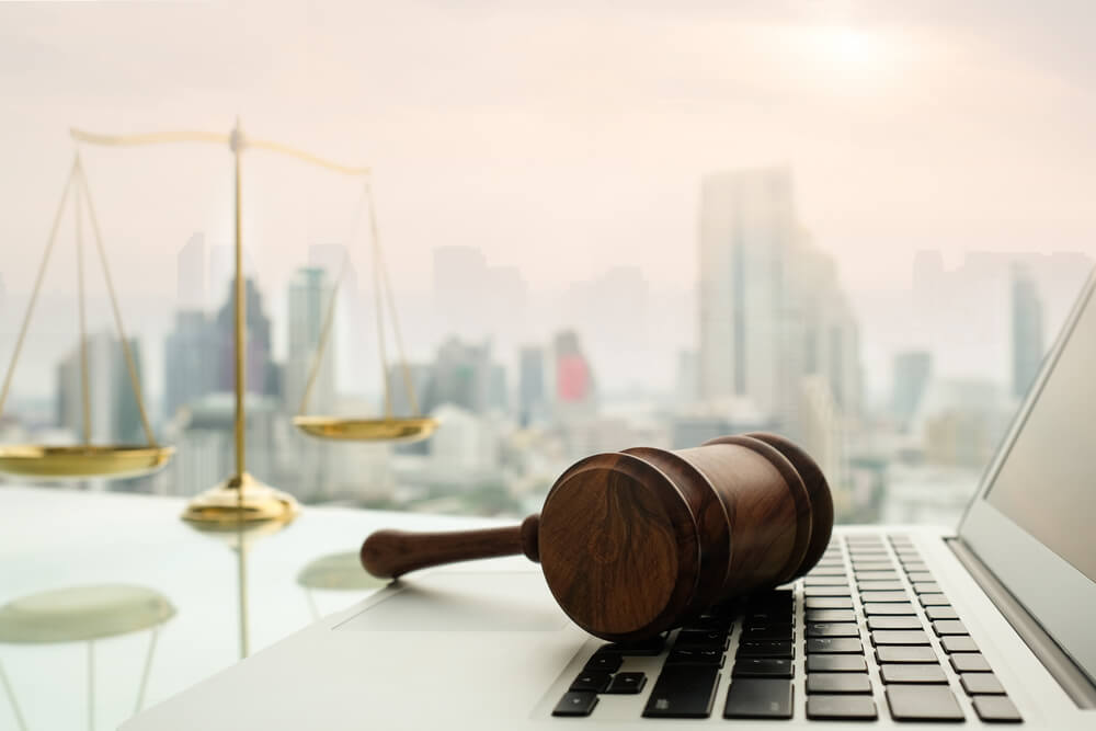 legal firms_law legal technology concept. judge gavel on computer with scales of justice on desk of lawyer.