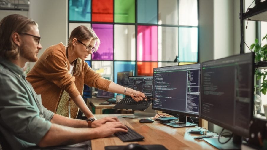Fractional CMO points at article of SaaS marketing tips on her co-worker's desktop computer