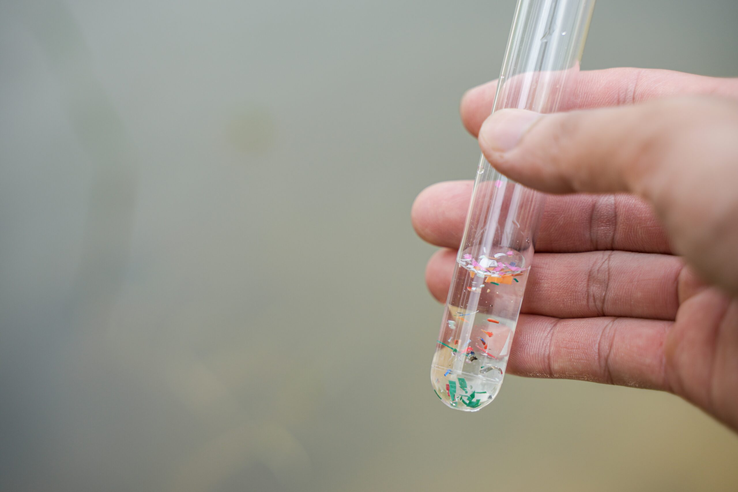 hand holding a tube of microplastics for mass pollution lawsuits