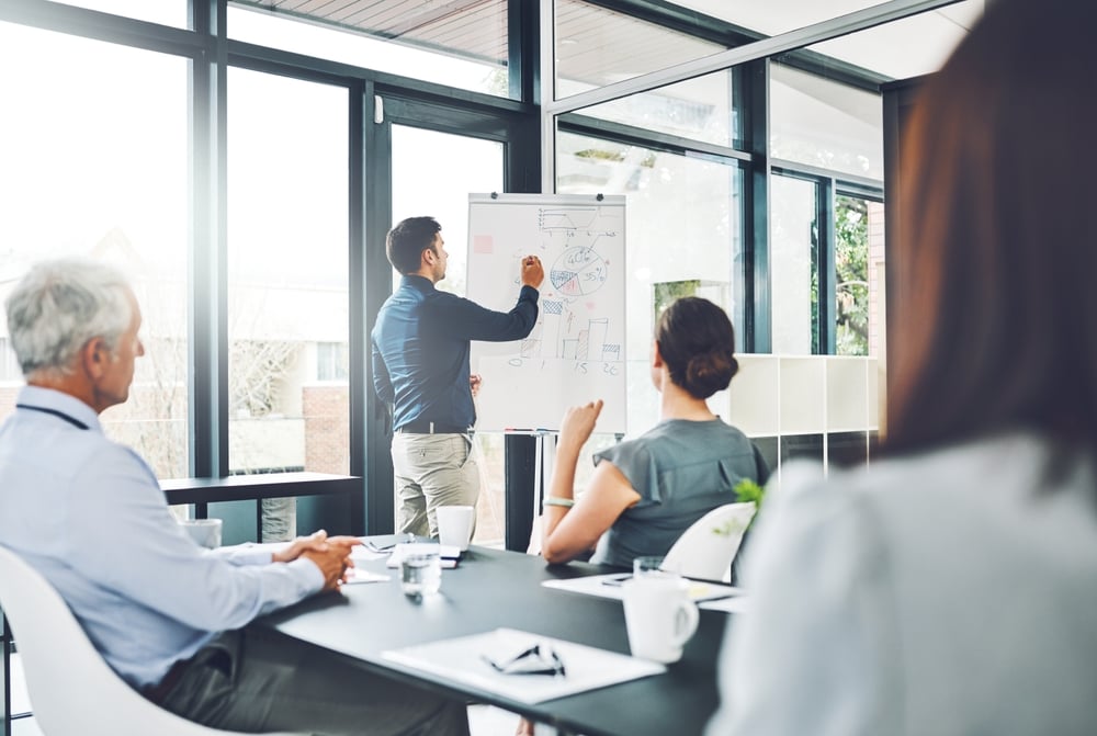 Presentation, graphs or businessman by board for writing, growth stats or revenue in meeting. Charts results, report or speaker teaching for training or sales coaching for learning in modern office