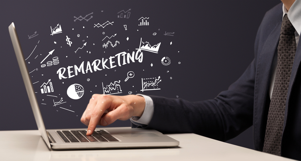 Businessman working on laptop with REMARKETING inscription, modern business concept